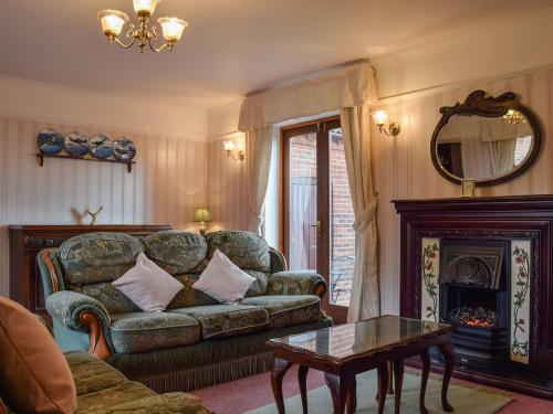 a living room with a couch and a fireplace at Glossoms Lodge in Scalford