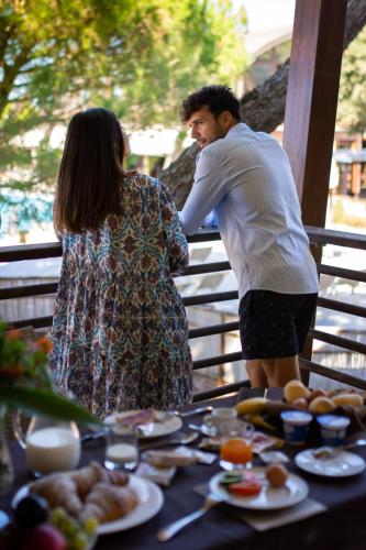 a man and a woman standing next to a table of food at Canado Club Family Village in Marina di Castagneto Carducci