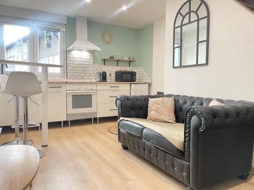 un salon avec un canapé et une cuisine dans l'établissement Le Duplex Cosy - Gare & Cité Gastronomique, à Dijon