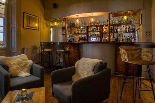 a bar with two couches and a bar with drinks at Housel Bay Hotel in Lizard