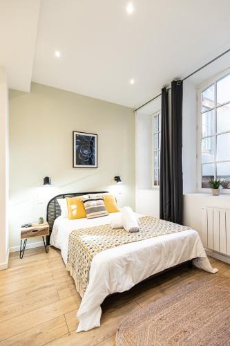 une chambre avec un grand lit et une fenêtre dans l'établissement Luna - Hôtel de Ville, à Saint-Étienne