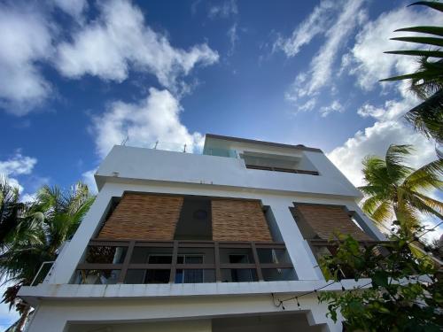 a white building with palm trees in the foreground at Casa Lambí in Cabrera