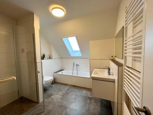 a bathroom with a toilet and a sink and a bath tub at Haus Leni in Butjadingen