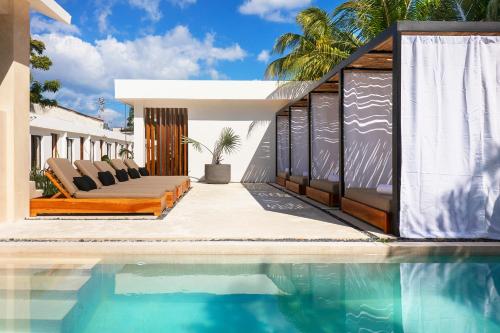 a house with a swimming pool next to a house at Illa Cozumel in Cozumel