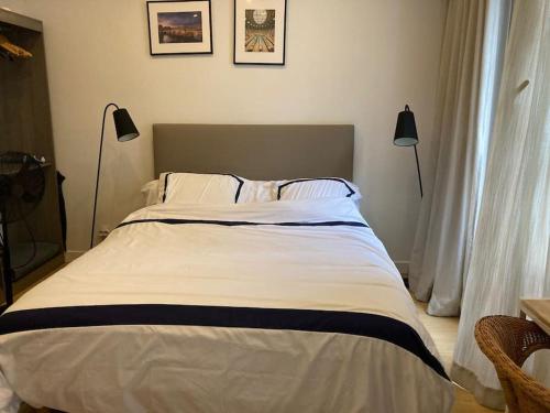 un grand lit dans une chambre avec deux lampes dans l'établissement Studio Saint Germain des près, à Paris