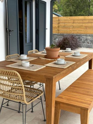 einen Holztisch und Stühle auf einer Terrasse in der Unterkunft Villa Couleur Nature in Salazie