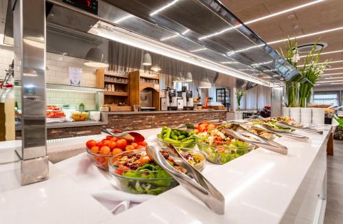 a buffet line with bowls of fruits and vegetables at Merom Golan Resort in Merom Golan