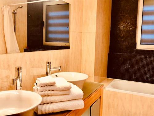 uma casa de banho com lavatório, espelho e toalhas em Bracara luxury guesthouse em Braga