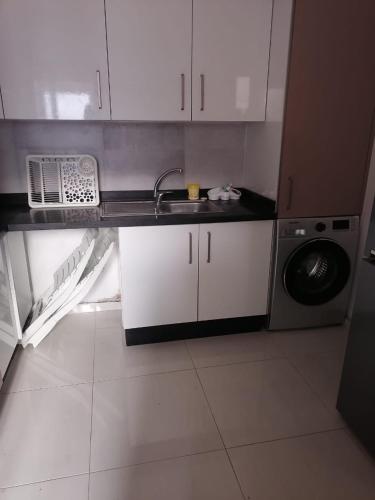eine Küche mit einer Spüle und einer Waschmaschine in der Unterkunft MAGIC HOUSE in Mansouria
