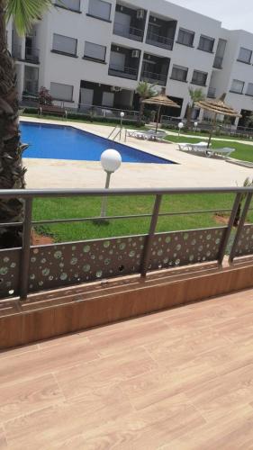 einen Zaun um einen Pool vor einem Gebäude in der Unterkunft MAGIC HOUSE in Mansouria