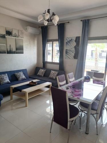 ein Wohnzimmer mit einem blauen Sofa und einem Tisch in der Unterkunft MAGIC HOUSE in Mansouria