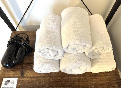 a pile of white towels sitting on a table at Sleeplicity London Heathrow in Feltham