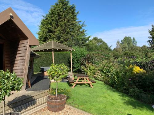 a garden with a picnic table and an umbrella at Burton Lodge Guest House & Spa in Brandesburton
