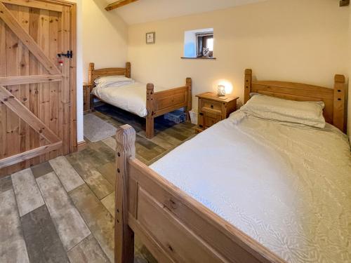 a bedroom with two beds and a sliding door at The Bobbin in Ashover