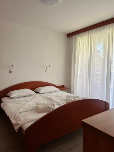 Schlafzimmer mit einem Bett mit weißer Bettwäsche und einem Fenster in der Unterkunft Apartment Aurora in Moravske-Toplice