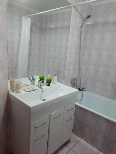 a bathroom with a white sink and a shower at Квартира с видом на парк,в минуте ходьбы от Акимата,Налоговой, Прокуратуры,Рахмета,Dostyk Mall,ЦОНа in Petropavlovsk