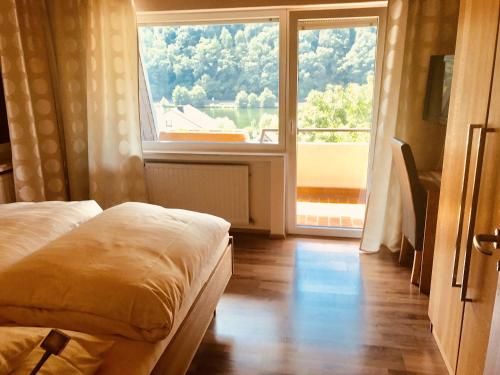 a room with a bed and a large window at Hotel Weingut Dehren in Ellenz-Poltersdorf