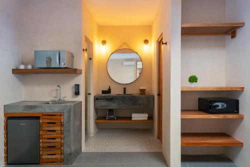 a bathroom with a sink and a mirror at Illa Cozumel in Cozumel