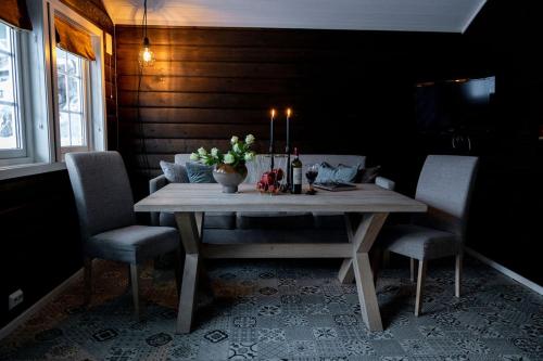 a dining room table with two chairs and a bottle of wine at Vollsnes Feriehus in Hjelle