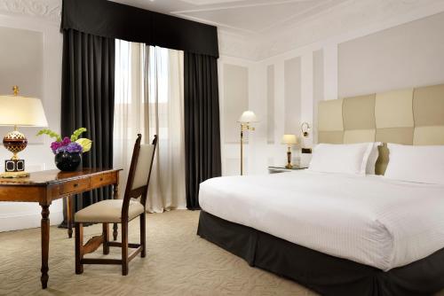 a hotel room with a bed and a desk and a bed at Hotel Splendide Royal - The Leading Hotels of the World in Rome