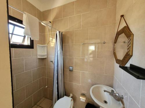 a bathroom with a sink and a toilet and a mirror at Pousada Genoveva - Casa a beira mar in Laguna