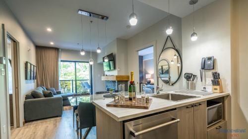 a kitchen with a sink and a living room at Château Morritt in Mont-Tremblant