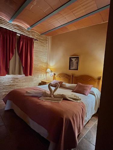 a bedroom with a bed with two towels on it at Hostal meson del rey in Olocau del Rey