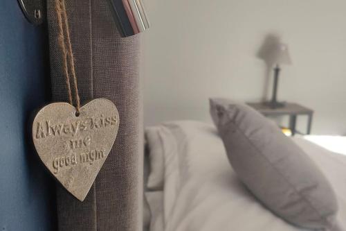 a wooden heart hanging on a wall next to a bed at Cosy Country Retreat in the Brecon Beacons in Crickhowell