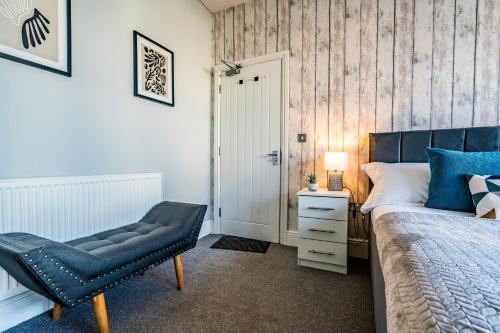 a bedroom with a bed and a chair and a door at Derby Road Suite in Kegworth