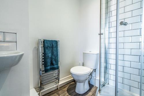 uma casa de banho com um WC e uma cabina de duche em vidro. em Derby Road Suite em Kegworth