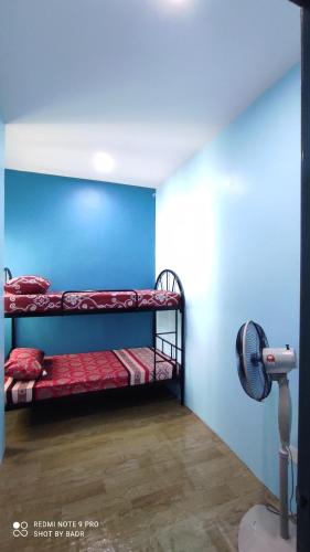 Zimmer mit 2 Etagenbetten und einem Ventilator in der Unterkunft Ain's Homestay in Kangar