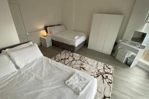 a small bedroom with two beds and a rug at Hamilton Apartments hosted by Maysa London in London
