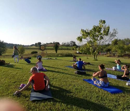 a group of people sitting in a field doing yoga at Agriturismo con Cucina tipica Nuova Scardua in Cavriana