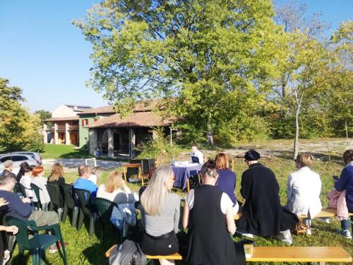 a group of people sitting around tables in the grass at Agriturismo con Cucina tipica Nuova Scardua in Cavriana