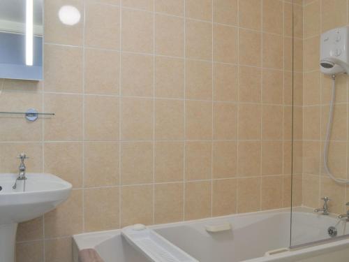 a bathroom with a shower and a tub and a sink at Bridgend Cottage in Lostwithiel