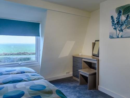 a bedroom with a bed and a desk and a window at Toadlands Farm in Eastville