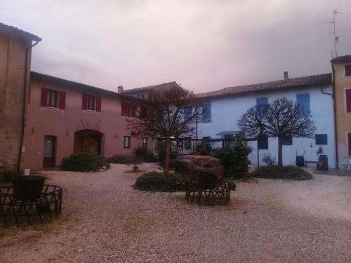 a group of buildings with benches in a courtyard at Agriturismo con Cucina tipica Nuova Scardua in Cavriana