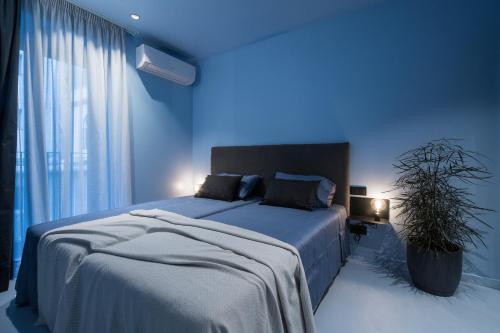 a blue bedroom with a bed and a potted plant at Lava in San Sebastián