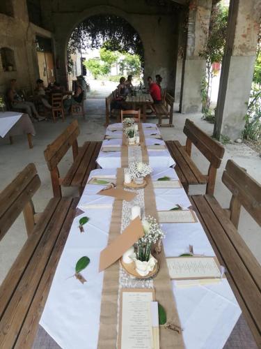 a long table with wooden benches and tables with flowers at Agriturismo con Cucina tipica Nuova Scardua in Cavriana