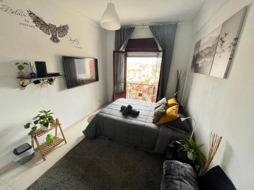 a living room with a bed and a window at Cardia’s Guest House in Sacavém