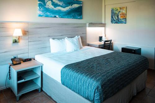 una habitación de hotel con una cama grande y una mesa en Punta Borinquen Resort en Aguadilla