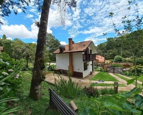 a small house in the middle of a garden at Chalé Recanto Boreal in Monte Verde