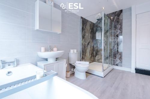 a white bathroom with a toilet and a sink at Stylish 3 Bedroom Townhouse close to Chester City Centre - Ideal for Families, Groups and Contractors in Hough Green