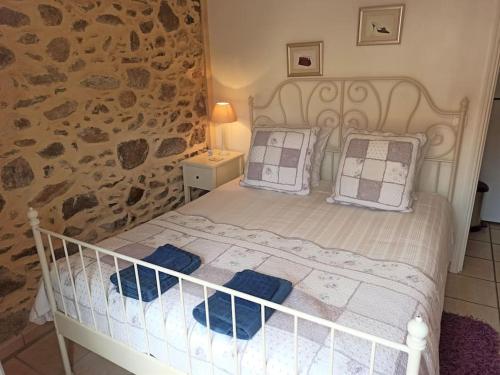 1 dormitorio con cama blanca y pared de piedra en Well equipped apartment, large terrace, BBQ & WIFI, en Ria