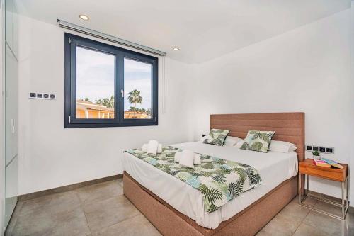 um quarto com uma cama grande e uma janela em Villa Corb Mari II em Playa de Muro