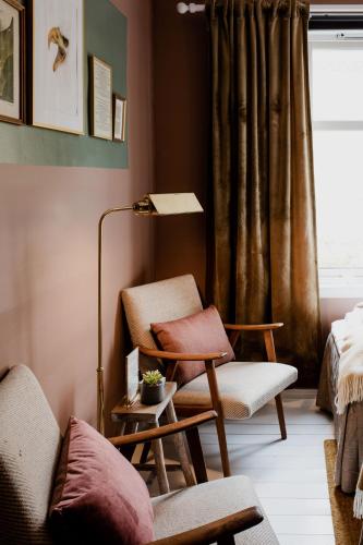 a living room with a chair and a lamp at Fjærland Fjordstove Hotell - Huseby Hotelldrift AS in Fjarland