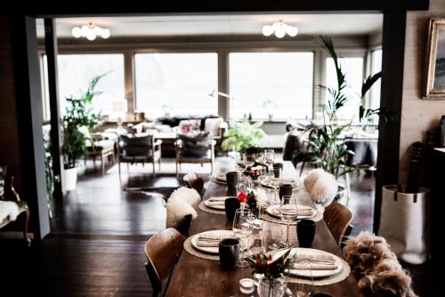 a dining room with a table with plates and glasses at Fjærland Fjordstove Hotell - Huseby Hotelldrift AS in Fjarland