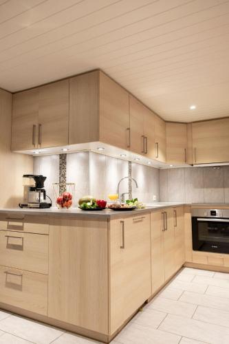 a kitchen with wooden cabinets and fruits on the counter at Vollsnes Feriehus in Hjelle