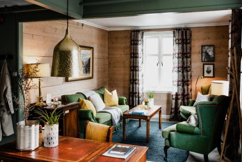 a living room with green chairs and a couch at Fjærland Fjordstove Hotell - Huseby Hotelldrift AS in Fjarland
