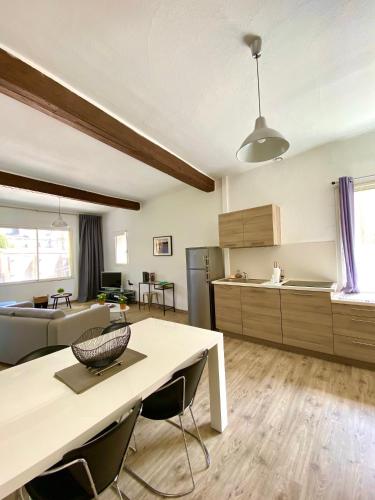 un salon avec une table et une cuisine dans l'établissement Arles Forum - Les Pénitents Bleus, à Arles